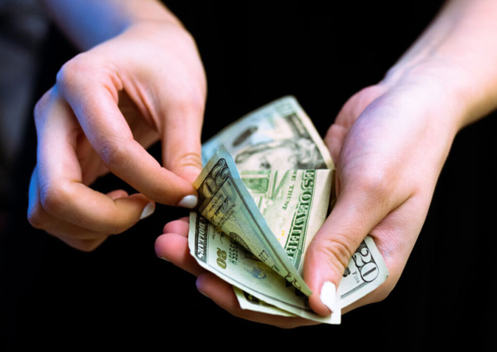 A person holding cash for monthly payment on installment agreement