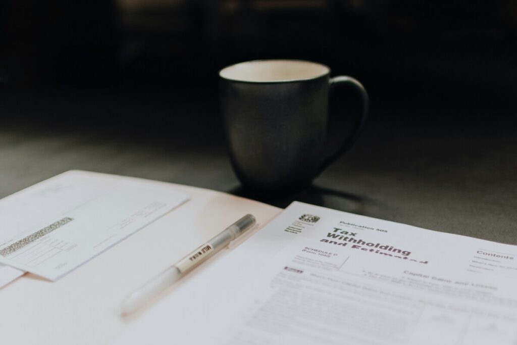 A tax withholding form and black cup on a table