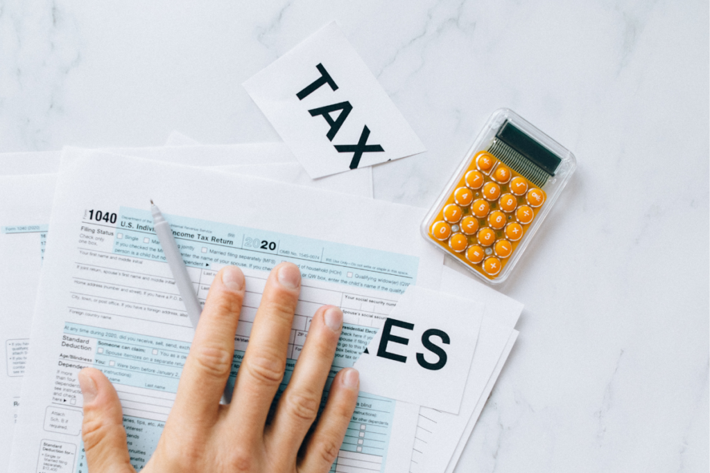 A few tax forms with a calculator and a note labeled 'Taxes' on it