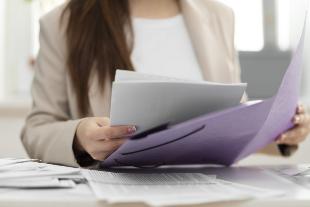 A woman gathering all the requirements for filing an Offer in Compromise with the IRS.