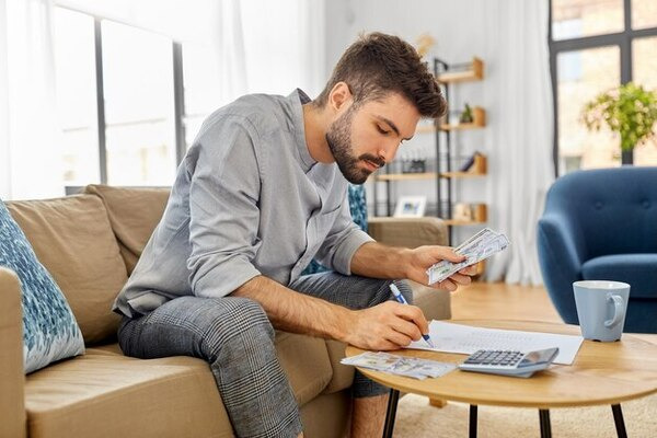 A man calculating both payroll tax and income tax to determine net income