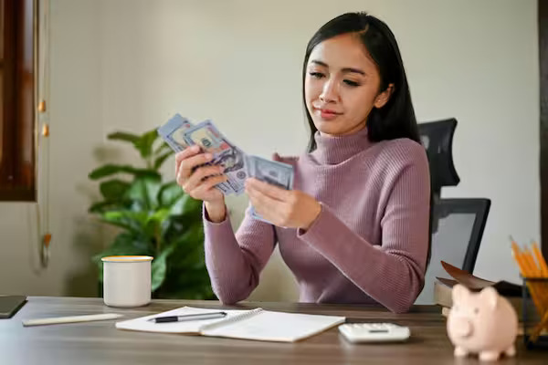 A woman counting income after payroll tax and income tax deductions