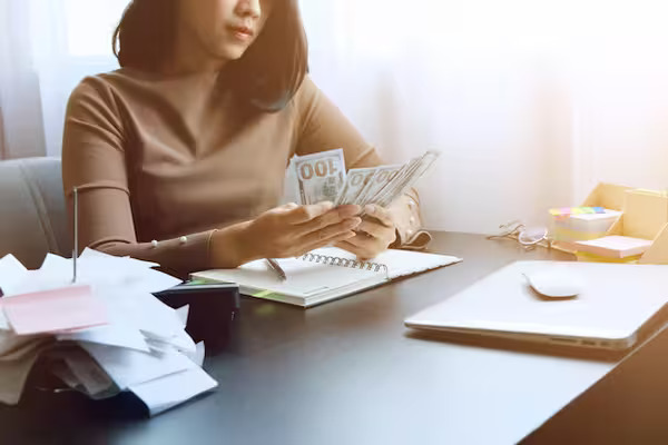 A woman counting money after tax deductions